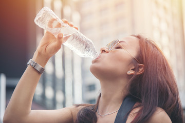 Wall Mural - woman drinking water during morning in city park