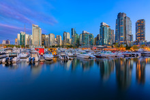 Sunset At Coal Harbour In Vancouver British Columbia With Downtown Buildings Boats And Reflections In The Water