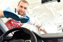 Professionelle Autowäsche Als Dienstleistung - Mann Reinigt Autoscheibe - Sicherheit Im Straßenverkehr Durch Saubere Frontscheibe Im Auto