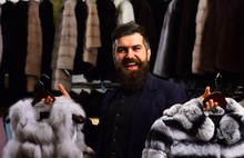 Guy With Happy Face Shows Fur Coats In Fashion Store.
