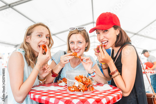 Foto Group of young multiracial girl friends eating seafood crab or crawfish at a out