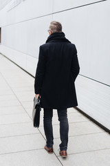 Rear view of man walking with briefcase