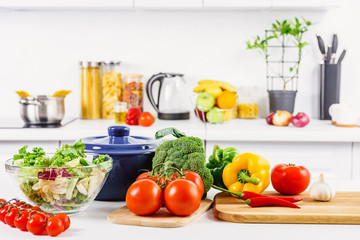 Wall Mural - ripe broccoli, tomatoes and bell peppers on table in light kitchen