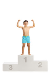 Wall Mural - Boy in swimwear standing on a winner's podium and showing muscles