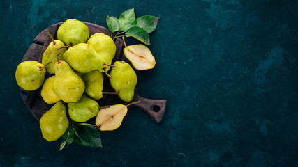 Wall Mural - Fresh pears on a black stone table. Fruits. Free space for text. Top view.