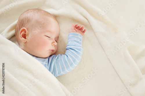 Fotografía Baby sleeping covered with soft white blanket