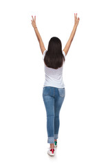 Wall Mural - back view of woman walking with hands in the air
