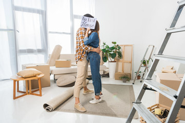 Wall Mural - obscured view of couple kissing behind our first house card at new home