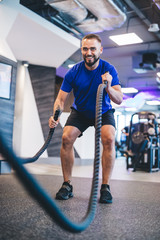 Wall Mural - Man exercising with ropes at the gym.