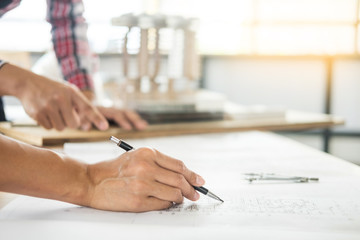 Wall Mural - Close-up Of Person's engineer Hand Drawing Plan On Blue Print with architect equipment, Architects discussing at the table, team work and work flow construction concept