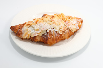 Wall Mural - Freshly baked croissant with nuts on a white plate