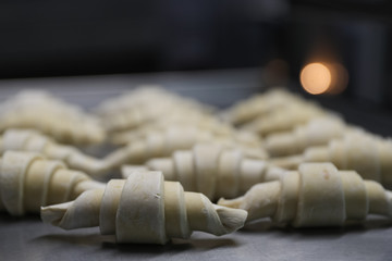 Wall Mural - Frozen pieces for croissants on a baking sheet in a bakery