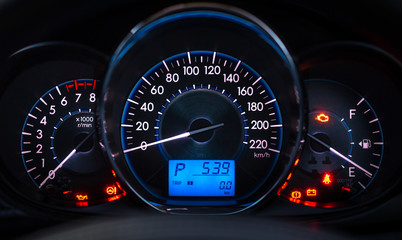 car meter with white and blue light at dark background