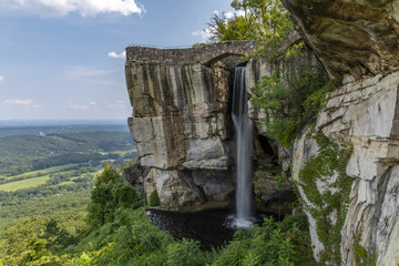 Wall Mural - High Falls Waterfall - A waterfall under a footbridge on the side of a cliff.