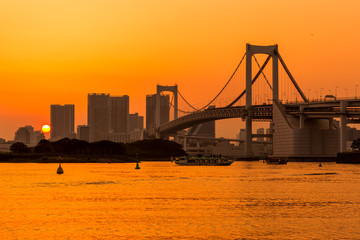 Fototapete - Tokyo skyline and rainbow bridge at sunset in Odaiba waterfront.