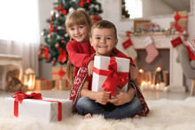 Cute Little Children With Christmas Gift Boxes At Home