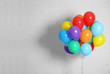 Bunch of bright balloons and space for text against brick wall