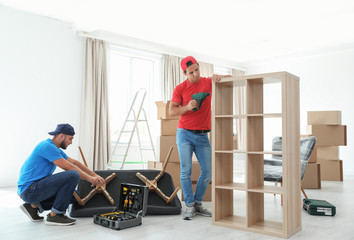 Wall Mural - Male movers assembling furniture in new house