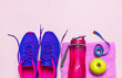 Fitness concept with Ultra violet pink female sneakers, water bottle, pink towel, apple on pastel pink background flat lay top view. Sports shoes, fitness, concept of healthy lifestile.