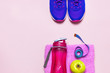 Fitness concept with Ultra violet pink female sneakers, water bottle, pink towel, apple on pastel pink background flat lay top view. Sports shoes, fitness, concept of healthy lifestile.