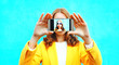 © rohappy - woman takes picture self portrait on smartphone on colorful blue background