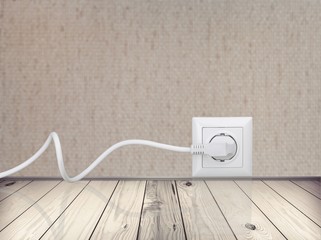 Canvas Print - White electrical plug in the electric socket on a wall