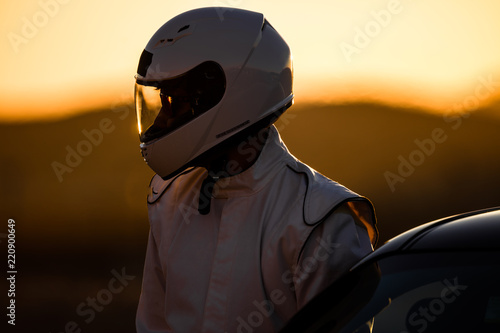 Fotomural A Helmeted Driver Preparing To Race At Sunrise