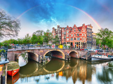 Amsterdam Canal With Typical Dutch Houses And Rainbow, Holland, Netherlands.
