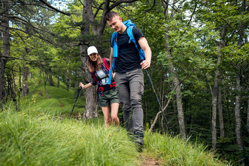 Young couple with backpack walking at forest and enjoy.Hiking and camping concept