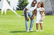 © LIGHTFIELD STUDIOS - african american father and daughter holding hands in park and looking away