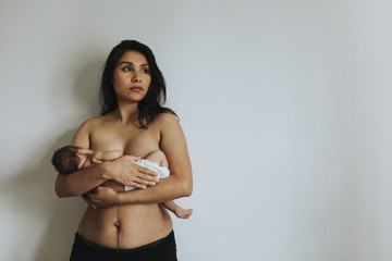 Wall Mural - naked mother holding her infant baby