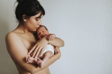 Wall Mural - naked mother holding her infant baby