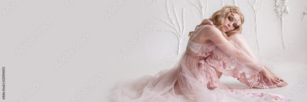 Delicate portrait of a young model girl. The image of the bride, a light lace dress in pink, a beautiful hairstyle and a natural make-up. Light photo studio, natural light from the window. - obrazy, fototapety, plakaty 