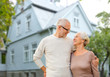 © Syda Productions - old age, accommodation and real estate concept - happy senior couple hugging over house background