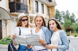 Beautiful woman traveler holding location map in hands in a city