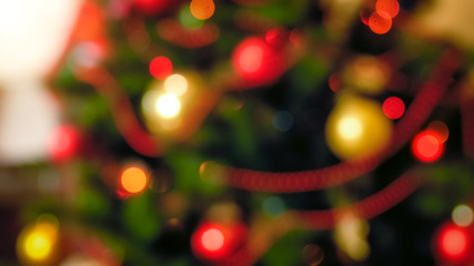 Wall Mural - Out of focus image of red and golden baubles hanging on Christmas tree at living room