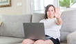 © Krakenimages.com - Down syndrome woman at home using computer laptop with open hand doing stop sign with serious and confident expression, defense gesture