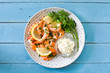 Grilled shrimps, parsley and lemon on blue wooden table. Top view