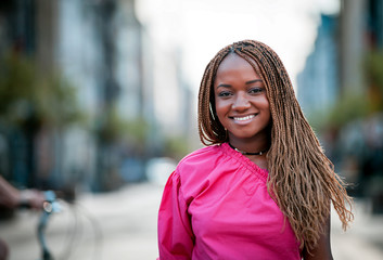 Wall Mural - Beautiful smiling African girl walking in the city street