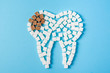 Sugar destroys the tooth enamel and leads to tooth decay. Tooth made of white and caries made of brown sugar cubes.