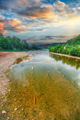 Wall Mural - Mountain river stream of water in the rocks with blue sky.