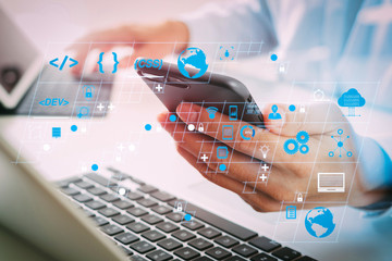 Poster - close up of businessman using mobile phone and laptop computer on white desk in modern office