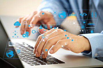 Fototapete - close up of businessman typing keyboard with laptop computer on wooden desk in modern office
