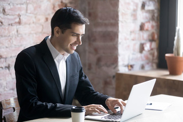 Smiling businessman or business owner working on computer in office at workplace. Concept of successful deal, good success job, no strees, easy work and congenial employment concept
