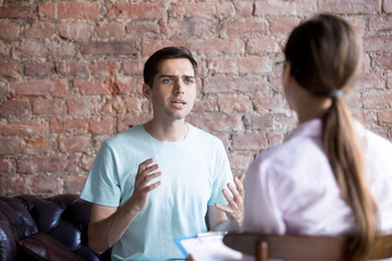 Young male visiting psychologist therapist counselor, doctor. Client patient talking to psychologist. Health problems, unrequited love, depression, drugs, disease and people need assistance concept