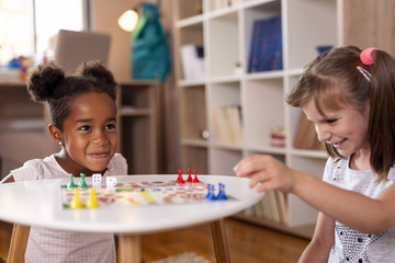 Wall Mural - Little girls playing ludo board game