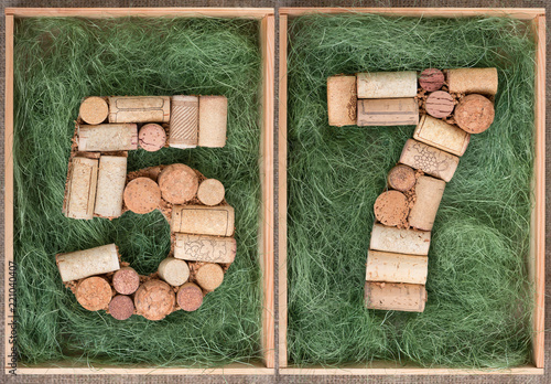 Fotografie, Obraz Number 57 fifty seven made of wine corks on green background in wooden box