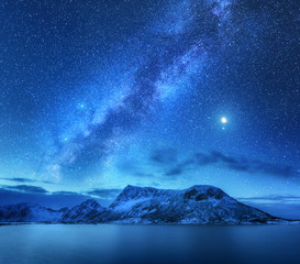 Wall Mural - bright milky way over snow covered mountains and sea at night in winter in norway. landscape with sn