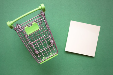 Shopping cart and shopping list isolated on color background.