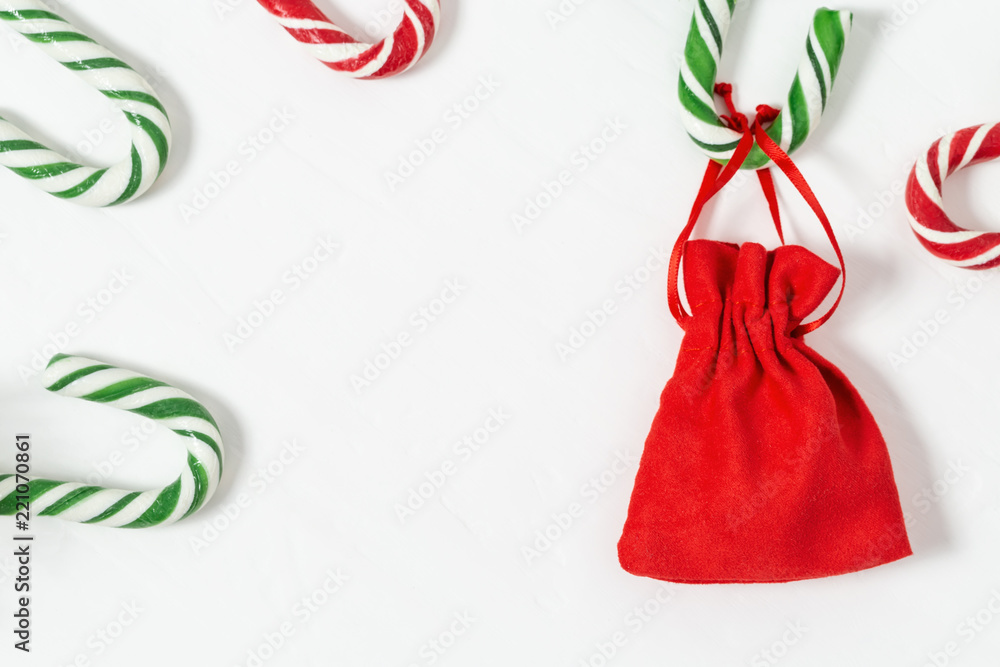Christmas background with candy canes and gift in small red bag ...